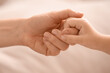 © Pixel-Shot - Little girl with her mother holding hands at home, closeup