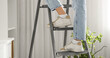 © Pixel-Shot - Legs of woman standing  on stepladder in room