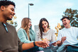 © DMegias - Diverse students group studying together and laughing outdoors