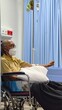 © Creativa Images - An elderly man wearing a face mask sits in a wheelchair while receiving intravenous (IV) fluids from a drip bag in a hospital ward or medical clinic