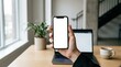 © saqlain - Businessperson holding smartphone with blank screen in modern office