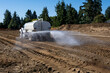 © knelson20 - New residential housing development construction site, non-potable water truck spraying water to keep dust down during earthworks project, sunny fall day