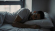 © Nopadol - Serene Slumber: A peaceful moment captured as a man rests his head on a pillow, peacefully asleep in his bed.
