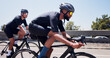 © EineroLens/peopleimages.com - Men, bicycle and team on bridge in city, speed and helmet for workout with sunglasses in summer. People, cycling and bike on road, triathlon training or outdoor with cardio challenge in urban town