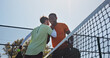 © EineroLens/peopleimages.com - Fitness, hug and padel with men on court together for practice or training session. Exercise, handshake or tennis with coach and player talking outdoor for skill or sports development from below
