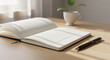 © Rapli - Minimalist workspace scene featuring an open blank notebook on a wooden desk, accompanied by a black pen and a small potted plant. Soft natural sunlight creates a calm and clean atmosphere, ideal for