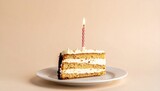 Layered cake slice with frosting, chocolate shavings, lit candle on white plate, beige background.