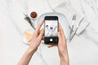 © Pixel-Shot - Female photographer with mobile phone taking picture of tasty pasta on marble background, top view