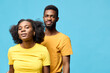 © SHOTPRIME STUDIO - Young African couple in matching yellow T shirts, posing confidently against a bright blue background, conveying happiness and connection in a vibrant, modern style