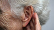 © A2Z AI  - Detailed view of an elderly woman's ear and hand, capturing the delicate wrinkles of aging skin and the soft texture of her white hair. A close-up on hearing concerns.