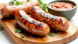 © venusvi - Delicious grilled sausages served on a wooden board with a side of savory sauce and fresh herbs.