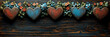 © sommersby - Vintage inspired arrangement of distressed wooden hearts, alternating red and blue, nestled within charming garland of small colorful flowers and leaves on dark rustic wooden background.