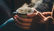 © Dinusha - A close-up of hands holding a warm, steaming ceramic mug of tea, wearing a thick knit sweater, emphasizing the tactile comfort of a quiet winter morning.