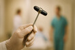 © Kanishka - Healthcare worker holding a neurological reflex hammer in a hospital corridor for diagnostic service