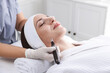 © New Africa - Woman undergoing microneedling procedure in beauty salon, closeup