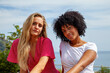 © Marino Bocelli - Two diverse young women friends posing together outdoors on a sunny day