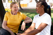 © StockMe - Diverse senior women friends enjoying outdoor conversation on a park bench, sharing smiles and connection, promoting aging gracefully and community