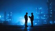 © Yus - Two silhouettes in hard hats confer at an illuminated industrial complex at night