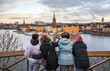 © C&A - Family on winter vacation in Stockholm admiring panoramic cityscape and taking a cheerful selfie from scenic viewpoint overlooking historic waterfront and colorful buildings