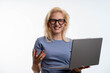© Nenad - Professional businesswoman working on laptop, smiling confidently, white backdrop