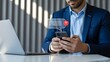 © BALAL - Businessman interacting with mobile phone and laptop in modern office setting