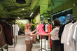 © velirina - Choosing clothes with friend in boutique, shoppers compare garments on rack. Fashion shopping support, retail purchase decision. Wardrobe update, outfit selection, customer service, indoor lifestyle.