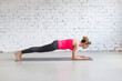 © junky_jess - Forearm plank exercise. Slim Caucasian 40 years old woman practice yoga in loft fitness studio indoor.