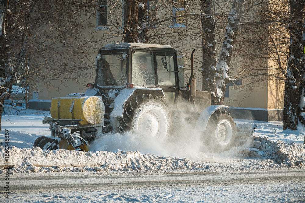 Snow Clearing Machine Using Salt Tractor equipped with a snowplow and yellow salt spreader attachment ...