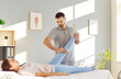 © Studio Romantic - Professional physiotherapist or chiropractor working with woman with leg pain. Male doctor examining leg of young female patient who is lying on bed at clinic or medical office. Physiotherapy concept