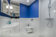 © alhim - This modern bathroom features a bold blue accent wall, stylish fixtures, and a contemporary design. It includes a shower, sink, and toilet, creating a functional and inviting space.