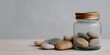 © progressman - Jar filled with small rocks sits on a table