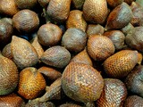 Close-up of fresh snake fruit or salak bunch in market. High angle view of exotic tropical fruit with scaly brown skin texture. Organic healthy food background from Southeast Asia