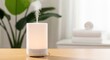 © SOEM - A white and black humidifier emitting steam on a wooden table with a green plant in the background.