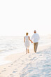© Birdsong Photography - Older Couple Walking Hand in Hand Along a Quiet Beach