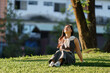 © Phimwilai - Young woman relaxing on grass enjoying sunlight