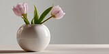 Elegant pink tulips in minimalist white ceramic vase on soft beige surface