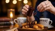 © yevhen89 - Indulgent adult woman pouring chocolate sauce on churros in a warm cafe. Concept of sweet indulgence and cozy moments