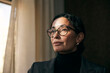 © Maskot - Contemplative female financial advisor wearing eyeglasses looking away