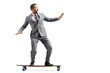 © Ljupco Smokovski - Full length shot of businessman in formal suit riding a skateboard