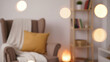 © Aline Shawn - A blurred indoor scene features a cozy reading or relaxation nook illuminated by warm, glowing lights.