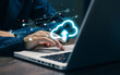 © saranyoo - A professional uses a laptop with a glowing cloud upload icon, representing cloud computing, data storage, file synchronization, digital transformation, and secure online infrastructure.