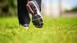 © Paula - Athletic woman walking on grass in sports shoes