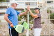 © Daniel - Senior couple playing paddle tennis or padel, outdoors in padel court enjoying and having fun together. Mature woman and old man high five after finish game