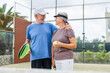 © Daniel - Portrait of couple of mature people playing padel game outdoors in a paddle tennis court together. Old man embracing mature woman teammate