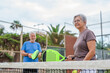 © Daniel - Portrait of couple of mature people playing padel game outdoors in a paddle tennis court together. Old man and mature woman teammate having fun enjoying