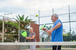 © Daniel - Portrait of couple of mature people playing padel game outdoors in a paddle tennis court together. Old man and mature woman teammate having fun enjoying