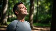 © Tatiana - Man enjoying fresh air and sunlight in nature, with eyes closed and happy expression. Relaxation and wellness concept for outdoor activities.