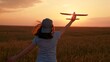 © Victoriia - Cheerful girl plays with toy airplane in plowed field. Happy child runs with toy airplane across field. Child dreams flying, childhood fantasies. Little girl wants to become pilot travel. Slow motion.