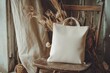 © mehaniq41 - White tote bag sits on rustic chair with dried plants, ambient lighting, warm tones. Neural network AI generated