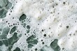 © mehaniq41 - Close-up of white soap bubbles resting on textured green marble surface. Bubbles add contrast and highlight marbles intricate patterns. Neural network AI generated